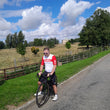 Load image into Gallery viewer, Cyclist on the road by a parkland on bike wearing bib shorts and cycling jersey from Wearwell