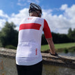 Load image into Gallery viewer, Back pockets of mens cycling jersey on male cyclist overlooking a river