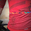 Load image into Gallery viewer, Man wearing a wearwell cycling jersey close up of logo on left hip